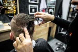 Klient po strihu pred zrkadlom v kaderníctve